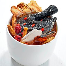 Black chicken herbal soup with goji berries and dried herbs